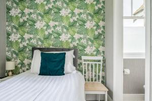 a bedroom with a bed with a green and white wallpaper at The Capsule Room at The Lairbeck in Keswick in Keswick