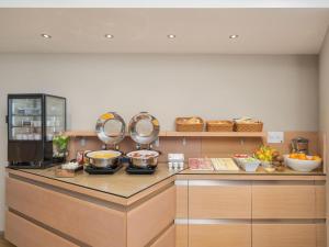 a kitchen with a counter with pots and pans at B&B HOTEL Padova Methis in Padova