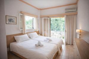 a hotel room with two beds with towels on them at Possidon in Agia Marina Aegina