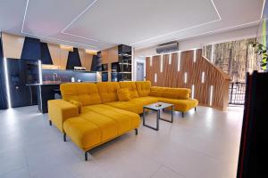 a living room with a yellow couch and a kitchen at Timm - Luxury Villas in Vodice