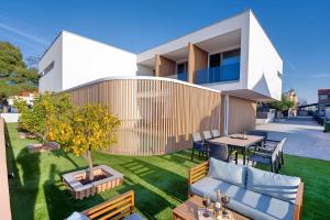 a house with a patio with a table and chairs at Timm - Luxury Villas in Vodice