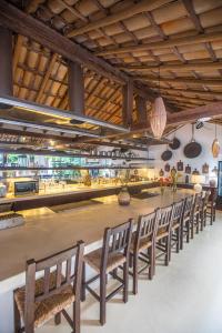 a row of chairs sitting in front of a counter at Monkey Casa Hotel in Trancoso