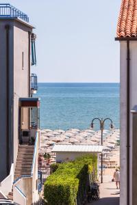 a view of a beach with umbrellas and the ocean at Hotel Helvetia in Lido di Jesolo