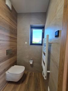 a bathroom with a toilet and a window at Widokowa Dąbrowa in Dąbrowa +13 photos
