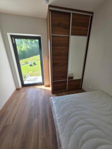 a bedroom with a bed and a large sliding glass door at Widokowa Dąbrowa in Dąbrowa