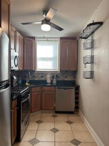 a kitchen with wooden cabinets and a ceiling fan at 8 minutes from 2026 FIFA World Cup Final! in Rutherford