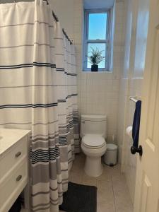 a bathroom with a toilet and a shower curtain at 8 minutes from 2026 FIFA World Cup Final! in Rutherford