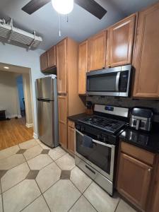 a kitchen with stainless steel appliances and wooden cabinets at 8 minutes from 2026 FIFA World Cup Final! in Rutherford +7 photos