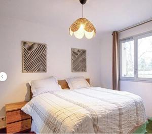 a bedroom with a bed and a chandelier at Villa Near Versailles in Feucherolles
