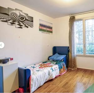 a bedroom with a bed and a window at Villa Near Versailles in Feucherolles
