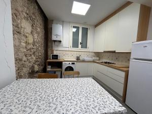 a kitchen with a table and a white refrigerator at El balcó de la plaça de la font in Tarragona