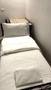 two beds with white sheets and a towel on them at Arcadia Hosting Piazza XX Settembre in Bologna +4 photos