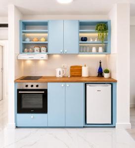 a kitchen with blue cabinets and a stove at Apartmani White House in Vrdnik