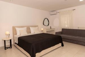a bedroom with a bed and a couch at Sea Oasis Residence in Limenas +24 photos