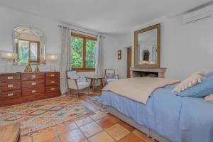 a bedroom with a bed and a dresser and a mirror at Maison Magdeleine in Saint-Tropez +27 photos