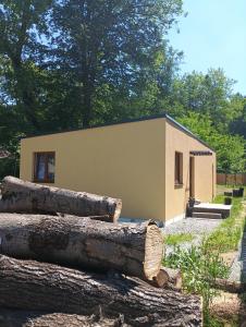 a building with a pile of logs in front of it at DOMA Les in Včelná