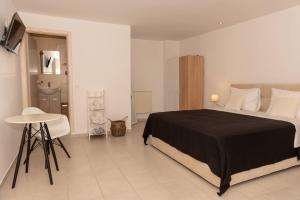 a bedroom with a bed and a table in it at Sea Oasis Residence in Limenas