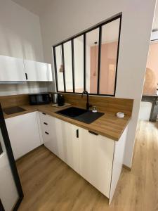 a kitchen with white cabinets and a sink at Demeure BelPel - Appartement Daurel in Bessan