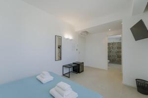 two white towels sitting on a blue bed in a room at Almarè Affittacamere in Favignana +81 photos