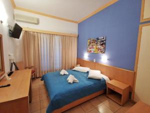a bedroom with a blue bed with two pillows at Possidon in Agia Marina Aegina +38 photos