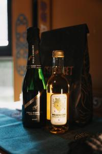 two bottles of wine and a bag on a table at Yurt Mongolia - Camp La Belle Vie in Berdorf