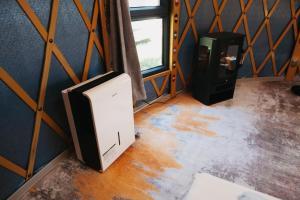 a small refrigerator in a room with a window at Yurt Mongolia - Camp La Belle Vie in Berdorf