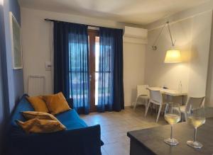 a living room with a blue couch and a table with wine glasses at Hotel La Posta di Torrenova in Orbetello