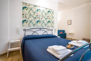 a bedroom with a blue bed with a painting on the wall at Valle dei Mulini - Apartment in Bellano
