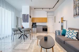 a living room with a couch and a table at Modern Sea-View Work Apartment, Sit-Stand Desk, Pool, Gym & Walk to Old Town in Paphos