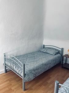 a bed in a room with a white wall at GEM Stay in Oberhausen