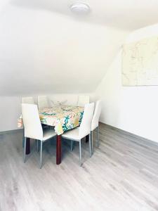 a dining room with a table and white chairs at GEM Stay in Oberhausen