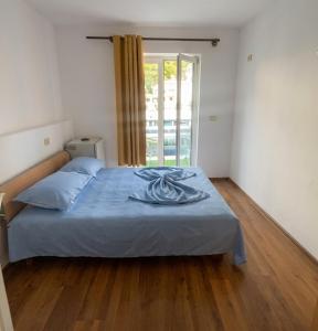 a bedroom with a bed with a blue blanket on it at Old Town Casa in Ulcinj