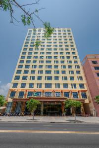 a large white building on a city street at Long Hotel in Danang