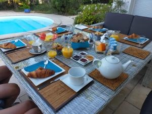 a breakfast table with breakfast foods and orange juice at La Nomade in Andernos-les-Bains