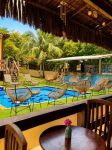 a patio with chairs and a table and a pool at EstrelaMar Boutique in Búzios