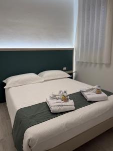 a bedroom with a bed with towels on it at Casa Cloe in LʼAquila