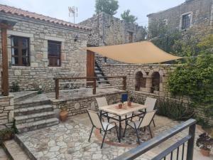 a patio with a table and chairs and a building at Villa Olive Old Qeparo in Qeparo