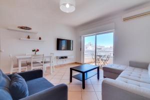 a living room with a couch and a table at Vale do Farol Cozy Retreat in Quarteira