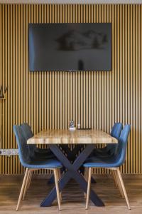 a dining room with a wooden table and blue chairs at Apartmán U mlýnu in Červená Voda