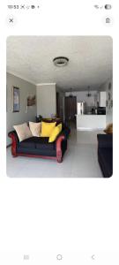 a living room with a couch with yellow pillows at New Kingston Condo Apt in Kingston