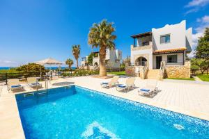 a villa with a swimming pool in front of a house at Spiros Beach Villa in Frangokastello
