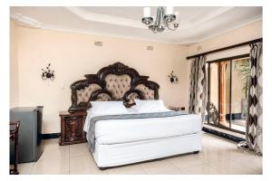 a bedroom with a large white bed in a room at Leon's Lodge in Choma +29 photos