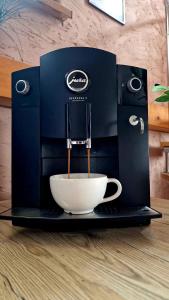 a coffee machine with a cup on a table at Apartments Sofia - Luxury Penthouse in Liptovský Mikuláš