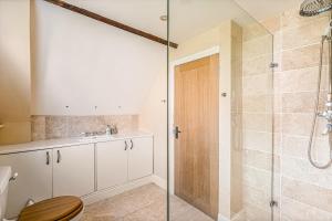 a bathroom with a shower and a toilet and a sink at The Coachmans Loft in Bix +12 photos