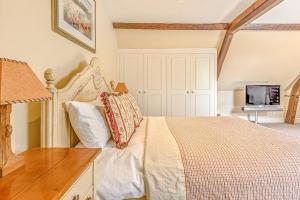 a bedroom with a bed and a desk and a tv at The Coachmans Loft in Bix