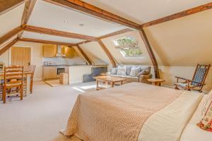 a bedroom with a large bed and a kitchen at The Coachmans Loft in Bix