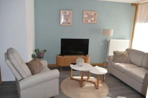 a living room with a couch and a tv at Ferienwohnung Carlo in Bindlach