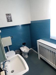 a blue bathroom with a toilet and a sink at Ël Sautafoss in Agliè +8 photos
