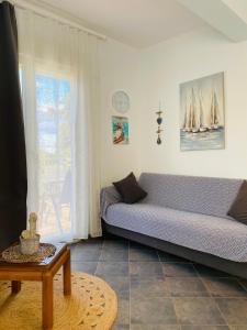 a living room with a couch and a window at FERRUM house in Hanioti