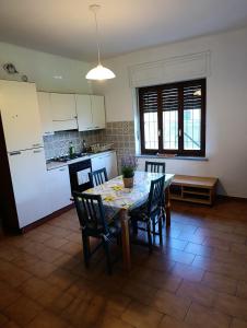 a kitchen with a table and chairs and a kitchen with white appliances at Ël Sautafoss in Agliè